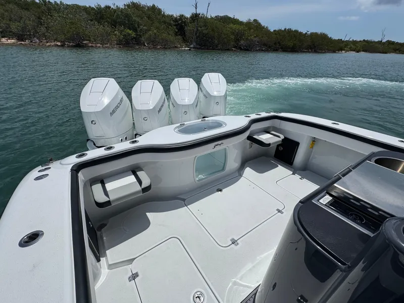 Slide: The Image of 2023 Yellowfin 42 boat with four outboard motors on a calm waterway. - 19