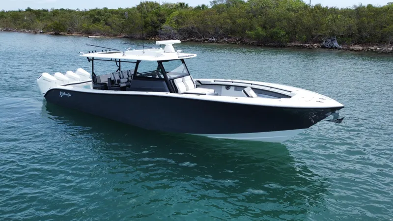 Slide: The Image of 2023 Yellowfin 42 boat cruising on a serene waterway with lush greenery in the background. - 2