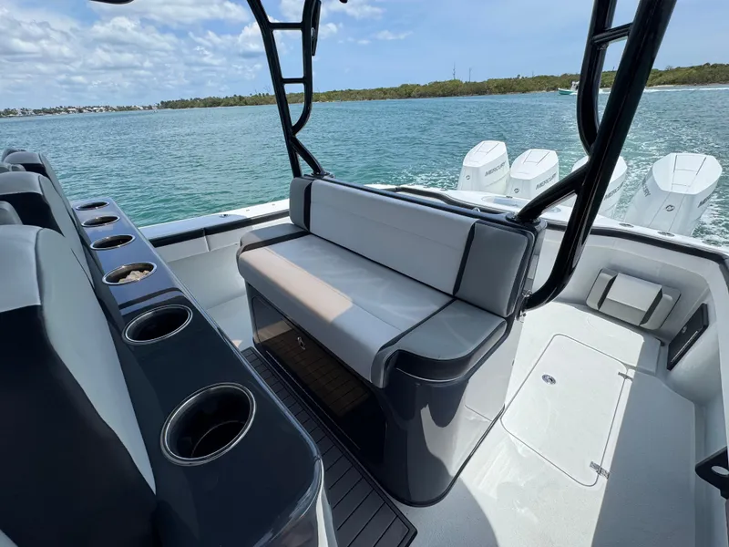 Slide: The Image of 2023 Yellowfin 42 boat interior with seating and cup holders, overlooking calm waters. - 23