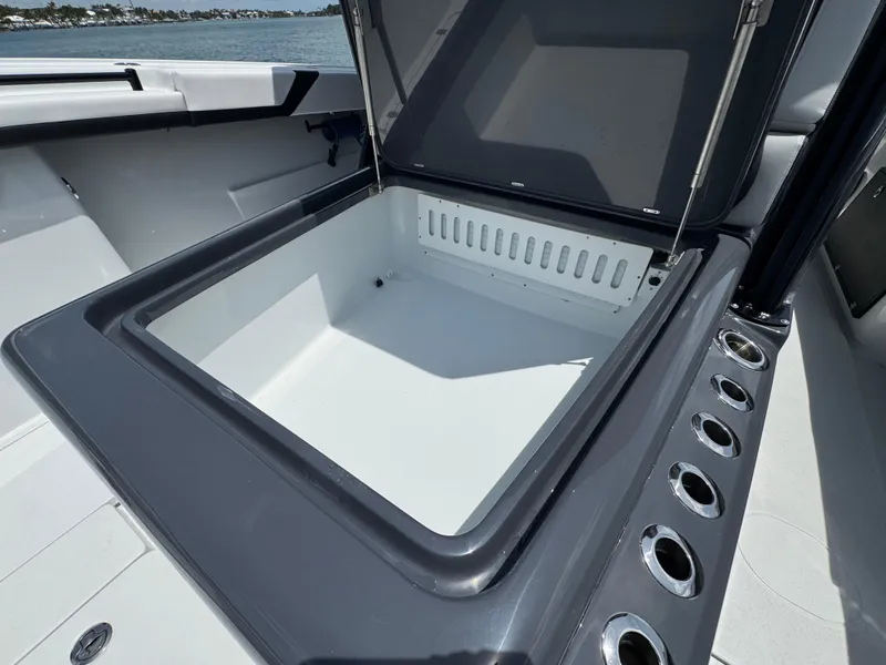 Slide: The Image of Open storage compartment on 2023 Yellowfin 42 boat, featuring sleek design and multiple cup holders. - 26