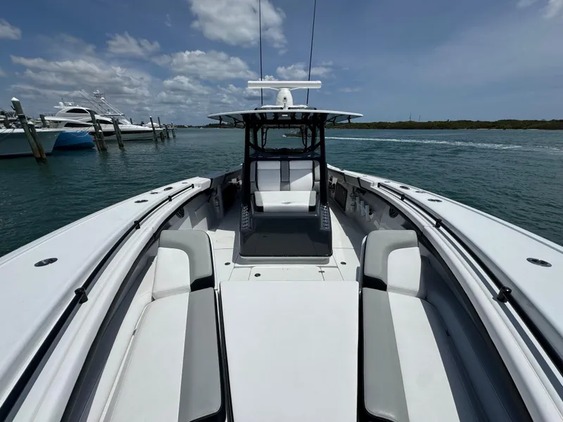 Slide: The Image of 2023 Yellowfin 42 boat on water, clear sky, docked yachts in background. - 30