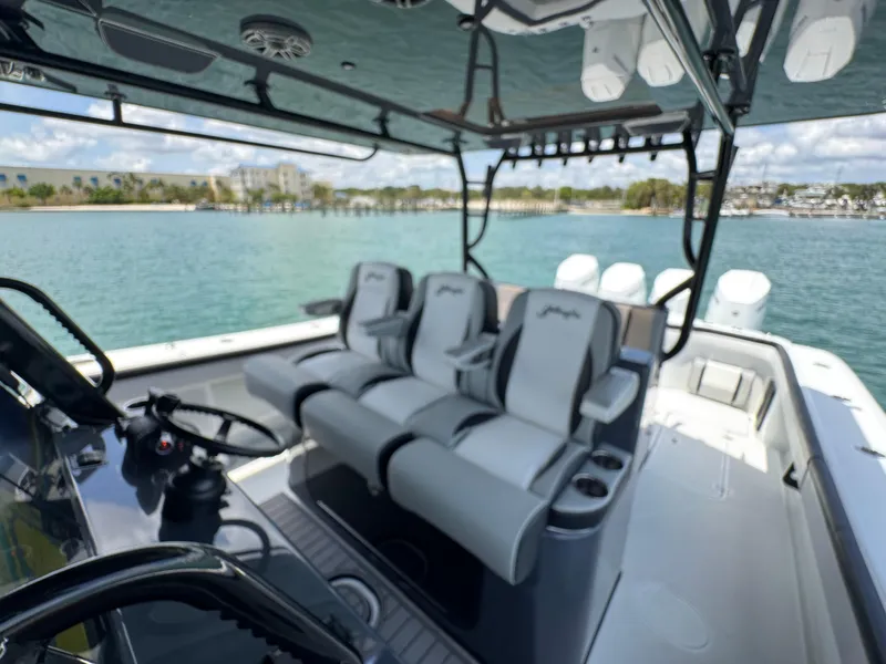 Slide: The Image of 2023 Yellowfin 42 boat interior with three cushioned seats, steering wheel, and ocean view. - 40