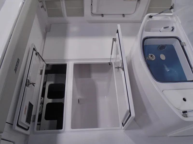 Slide: The Image of Interior view of a 2026 Jupiter 30 boat, featuring open storage compartments. - 19