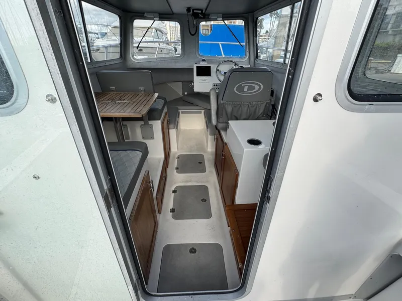 Slide: The Image of 2024 Defiance San Juan 220 boat interior with seating, steering wheel, and navigation equipment. - 10
