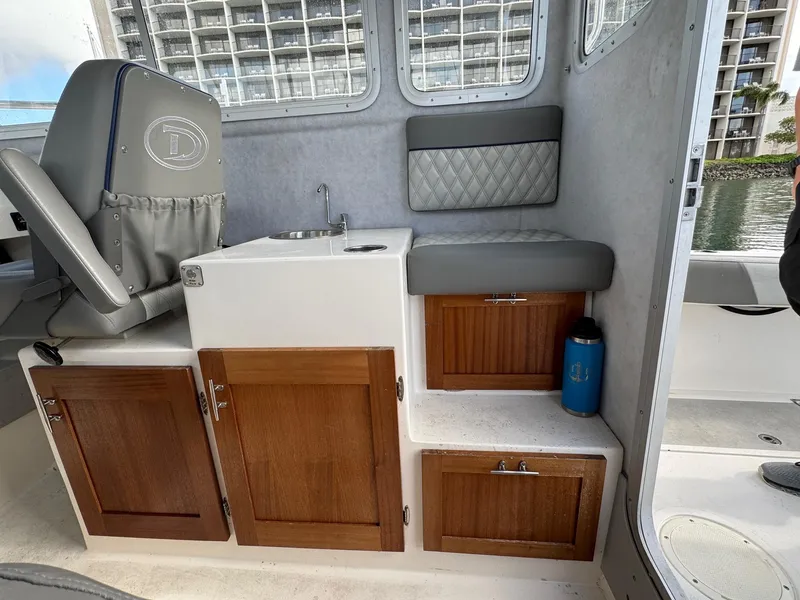 Slide: The Image of Interior of 2024 Defiance San Juan 220 boat with seating, sink, and storage cabinets. - 11