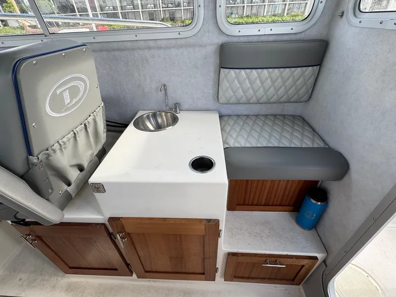 Slide: The Image of 2024 Defiance San Juan 220 interior with sink, seating, and storage cabinets. - 12