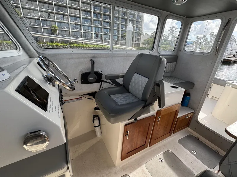 Slide: The Image of 2024 Defiance San Juan 220 boat interior with steering wheel and seating. - 13