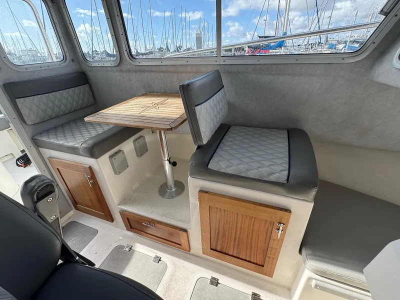 Slide: The Image of 2024 Defiance San Juan 220 interior with seating, table, and storage cabinets. - 14