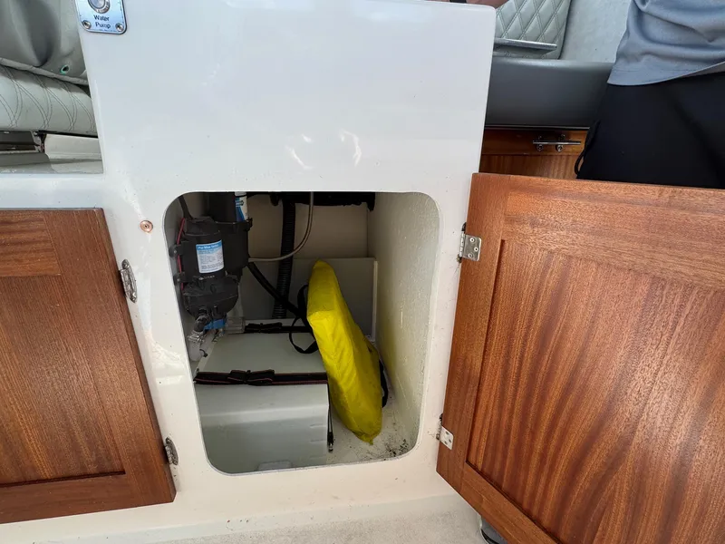 Slide: The Image of Open storage compartment on 2024 Defiance San Juan 220 boat with wooden doors. - 16