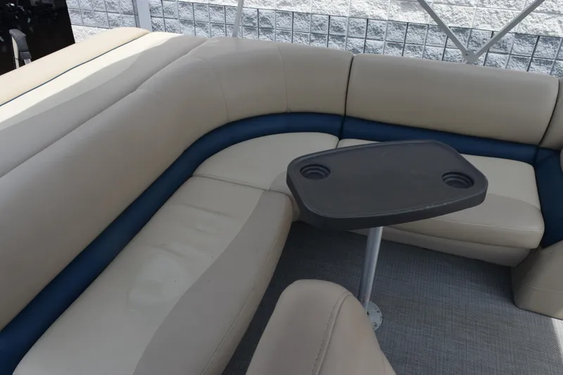 Slide: The Image of 2017 Manitou Aurora LE 21 RF SHP boat interior with beige seating and a small table. - 10