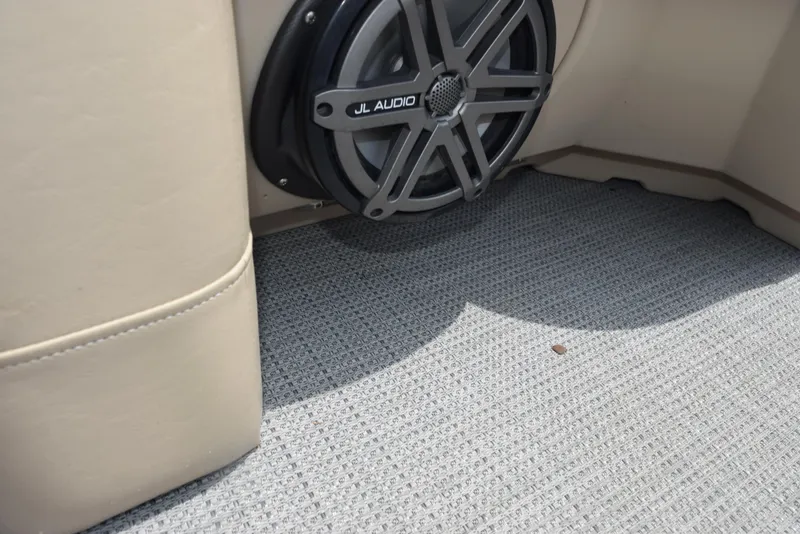 Slide: The Image of 2017 Manitou Aurora LE 21 RF SHP boat interior with JL Audio speaker and carpeted floor. - 14