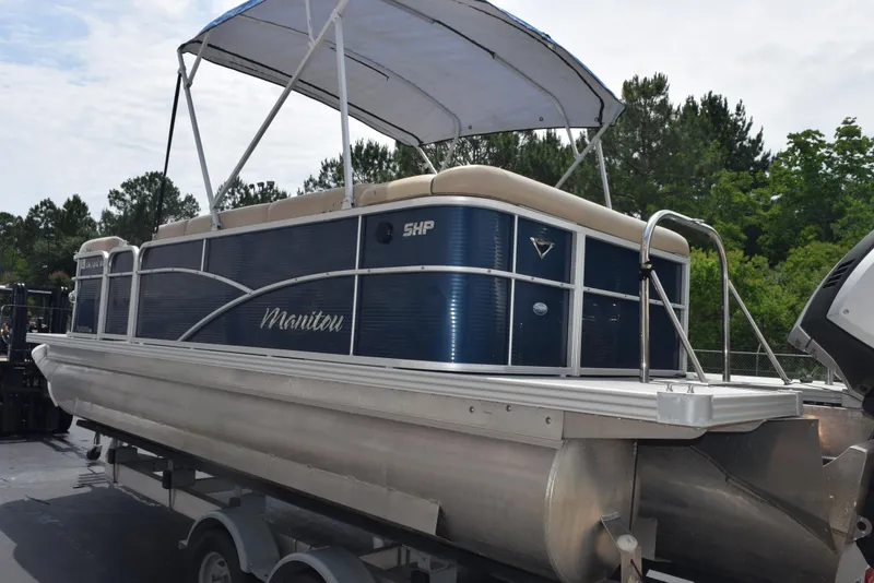 Slide: The Image of 2017 Manitou Aurora LE 21 RF SHP pontoon boat on trailer, blue and silver design. - 6