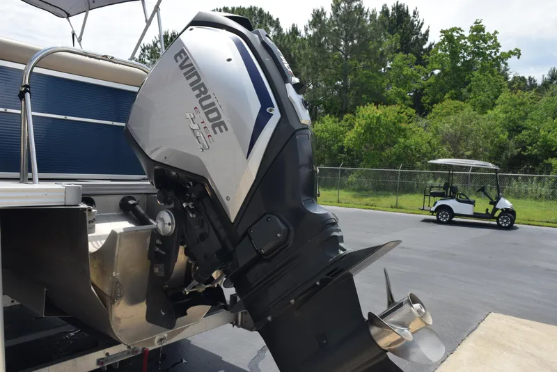 Slide: The Image of 2017 Manitou Aurora LE 21 RF SHP with Evinrude outboard motor in a parking lot. - 7