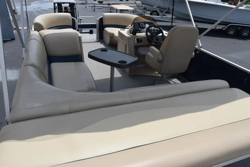 Slide: The Image of 2017 Manitou Aurora LE 21 RF SHP pontoon boat interior with beige seating and steering console. - 8