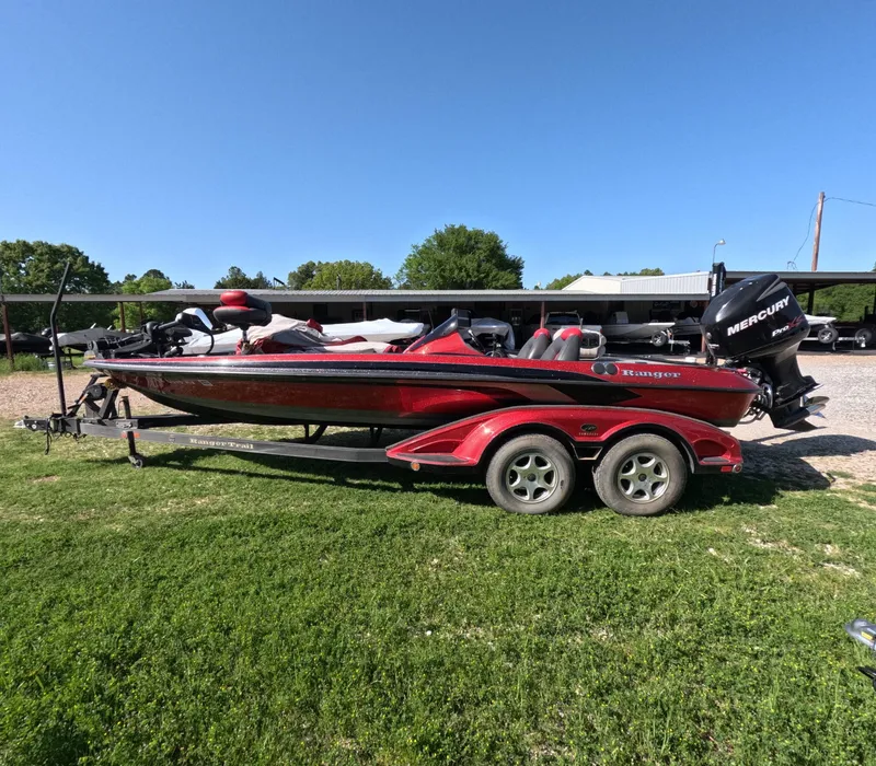 Slide: The Image of 2007 Ranger Z21 Comanche boat on trailer, red color, parked on grass. - 0