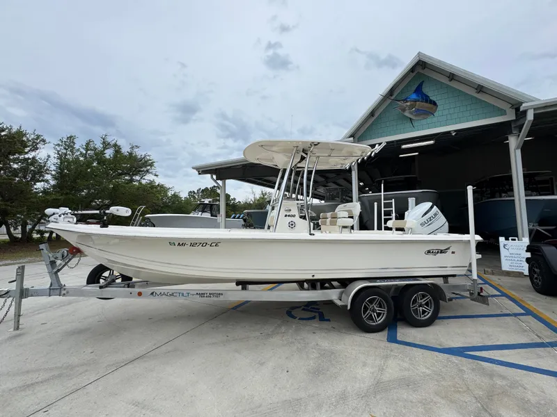 Slide: The Image of 2024 Bulls Bay 2400 boat on trailer outside a building, overcast sky. - 1
