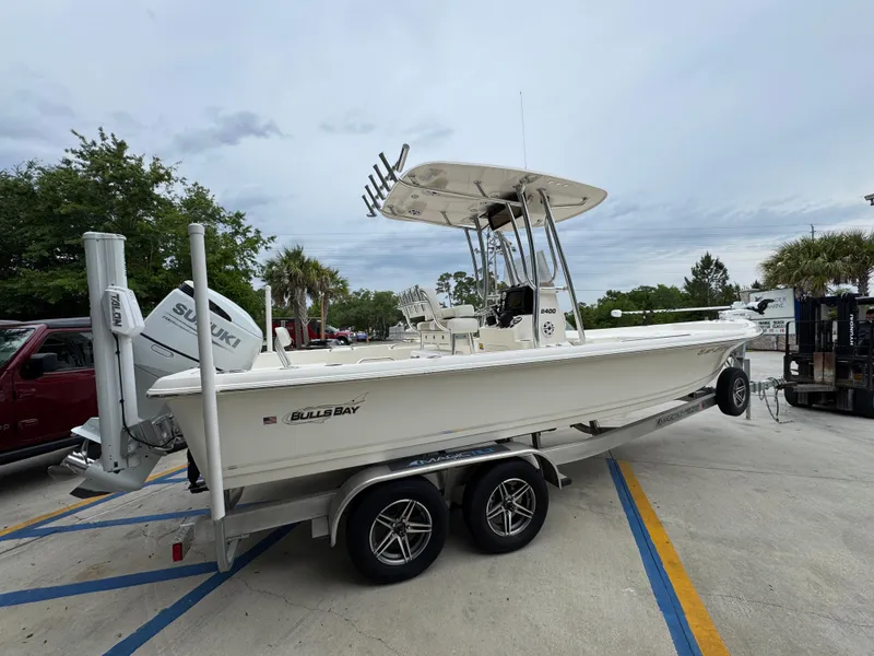 Slide: The Image of 2024 Bulls Bay 2400 boat on trailer, parked outdoors, featuring a sleek white design. - 11