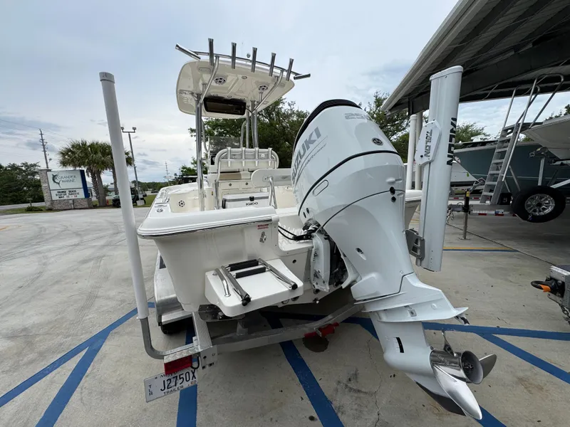 Slide: The Image of 2024 Bulls Bay 2400 boat with powerful outboard motor, parked in a marina. - 16