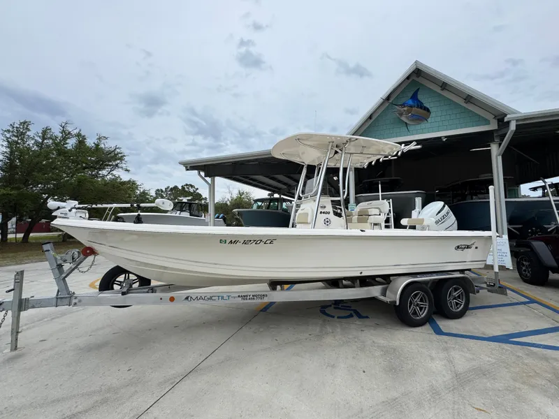 Slide: The Image of 2024 Bulls Bay 2400 boat on trailer, parked outdoors near a building. - 2