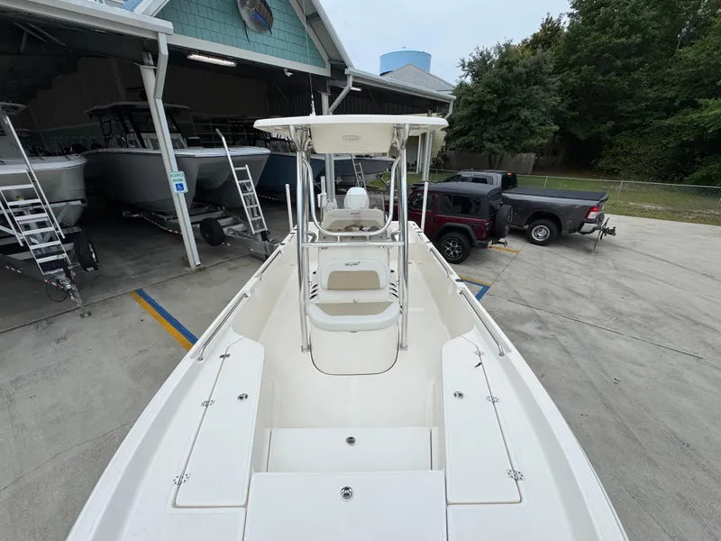 Slide: The Image of 2024 Bulls Bay 2400 boat at a marina, showcasing spacious deck and seating. - 22