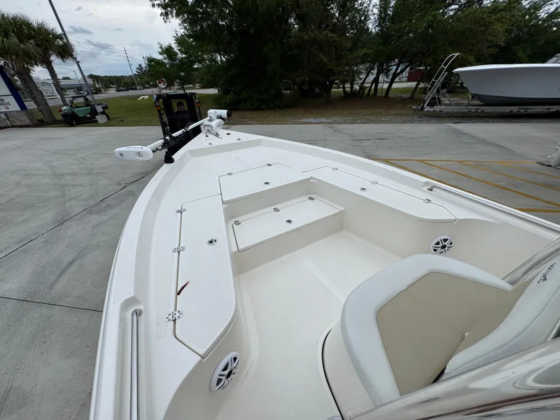Slide: The Image of 2024 Bulls Bay 2400 boat with spacious deck and seating, parked outdoors. - 24
