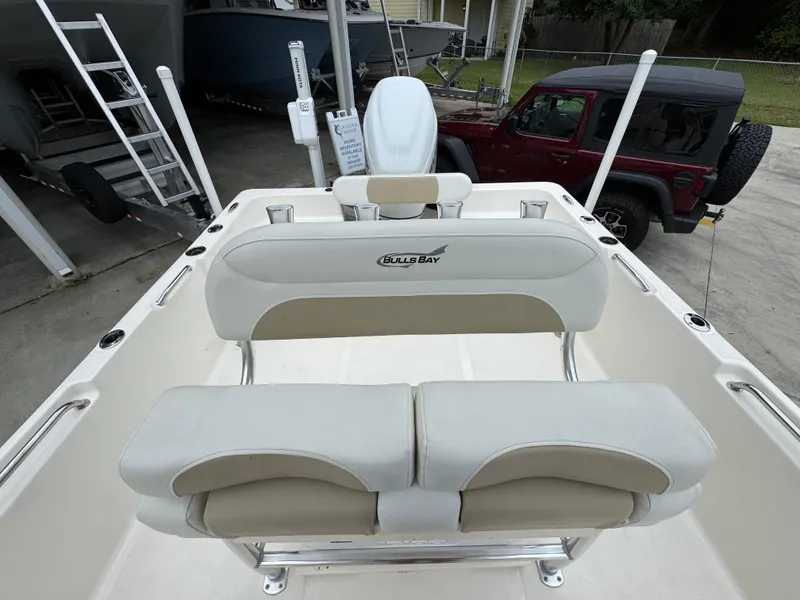 Slide: The Image of 2024 Bulls Bay 2400 boat interior with cushioned seating and steering console. - 28
