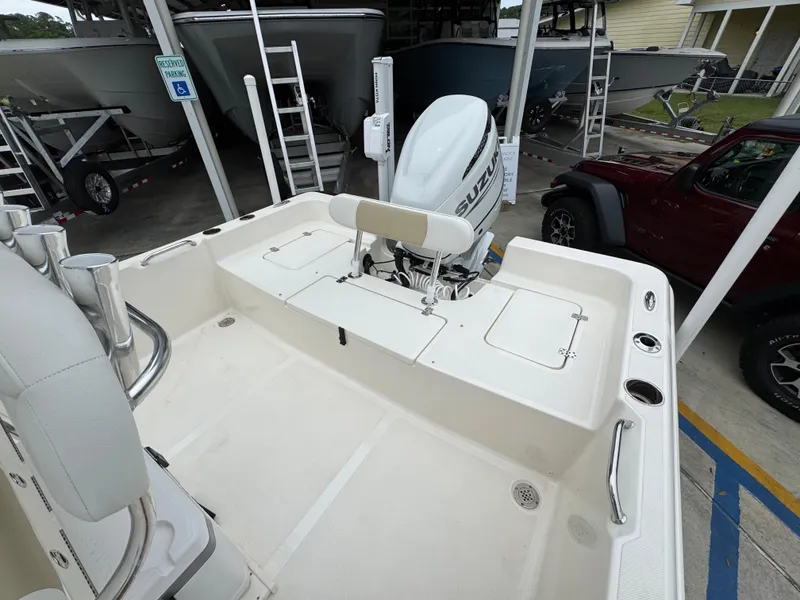 Slide: The Image of 2024 Bulls Bay 2400 boat with Suzuki outboard motor in a storage facility. - 35