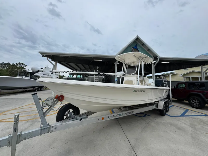 Slide: The Image of 2024 Bulls Bay 2400 boat on trailer, parked outdoors near a covered structure. - 4