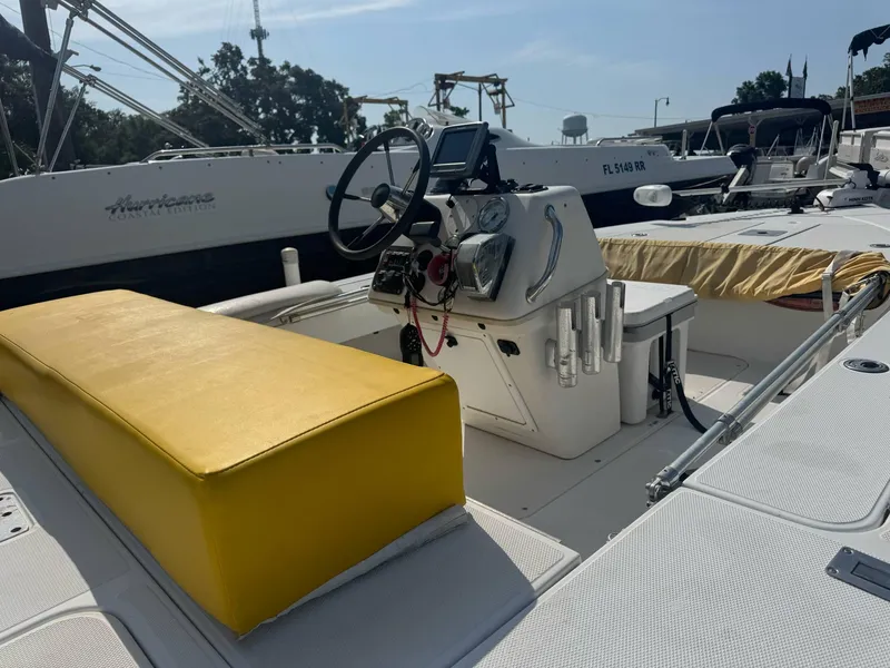 Slide: The Image of 2002 Ranger 191 Cayman boat with yellow seating and steering console in marina. - 2