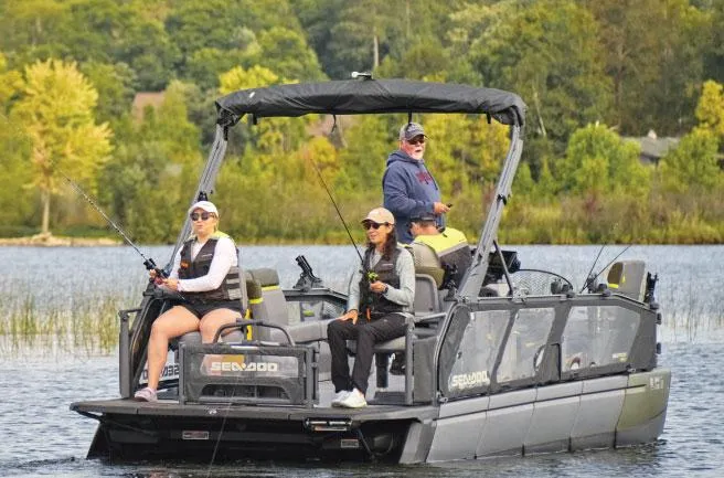 Slide: The Image of 2025 Sea-Doo Switch™ Fish 21 pontoon boat with anglers on a scenic lake. - 14