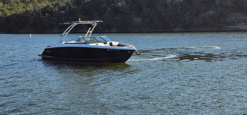 Slide: The Image of 2022 Cobalt R6 boat cruising on a serene lake with forested shoreline. - 1