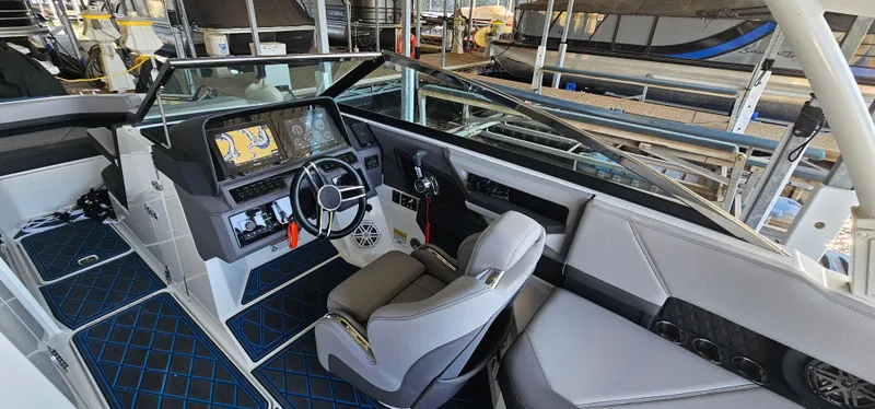 Slide: The Image of 2022 Cobalt R6 boat interior with modern dashboard and seating in a marina setting. - 10
