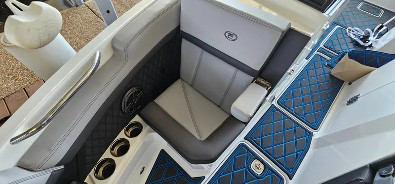 Slide: The Image of 2022 Cobalt R6 boat interior with gray and blue diamond-stitched seating and cup holders. - 26