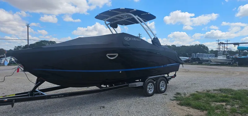Slide: The Image of 2022 Cobalt R6 boat on trailer, covered, parked outdoors under blue sky. - 3