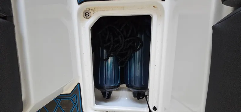 Slide: The Image of 2022 Cobalt R6 boat storage compartment with two blue fenders and black ropes. - 34