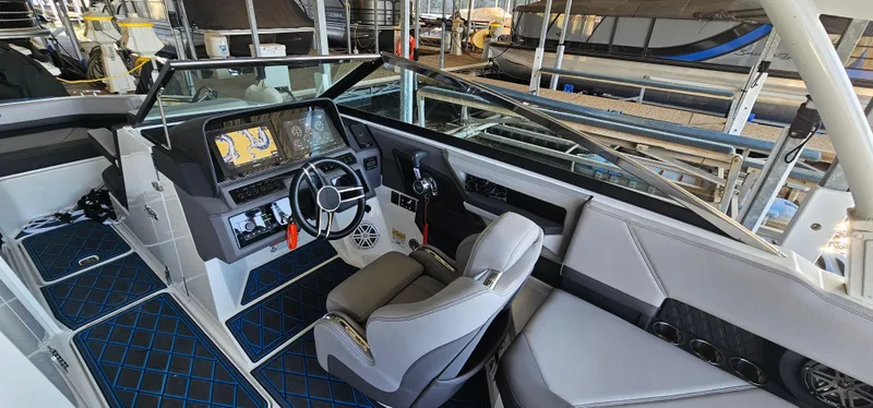 Slide: The Image of 2022 Cobalt R6 boat interior with modern dashboard and seating in a marina setting. - 9