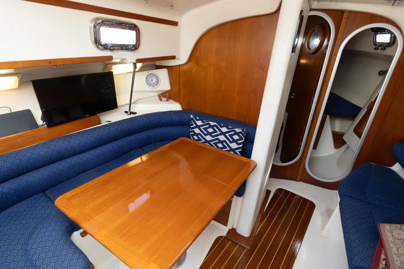 Slide: The Image of Interior of 2011 Hake Seaward 32 RK sailboat with blue seating and wooden table. - 23