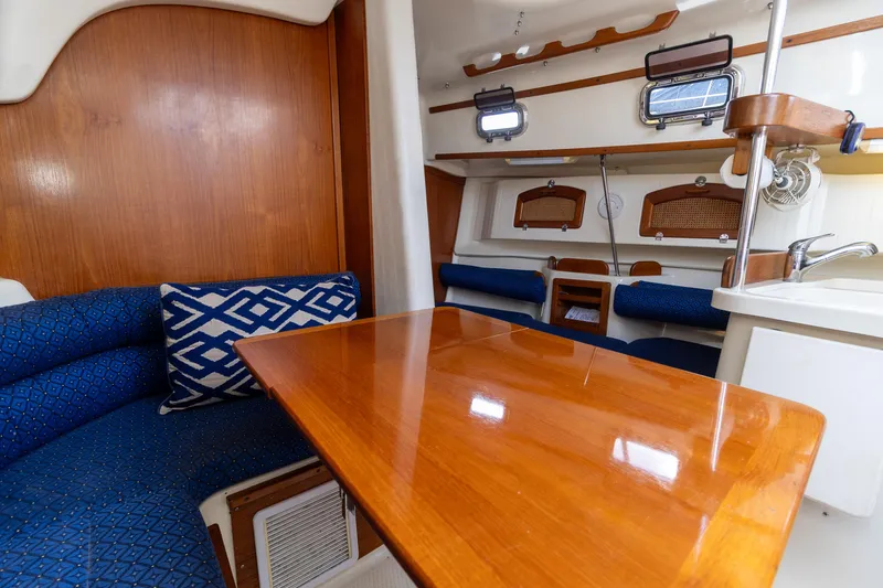 Slide: The Image of Interior of 2011 Hake Seaward 32 RK sailboat with wooden table and blue seating. - 24