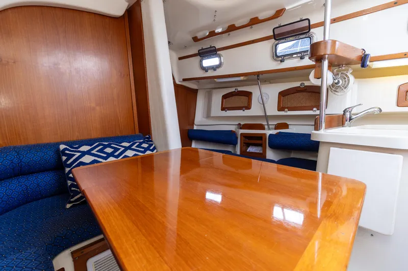 Slide: The Image of Interior of 2011 Hake Seaward 32 RK sailboat with wooden table and blue seating. - 28