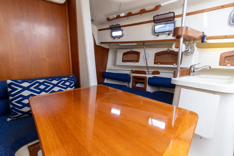 Slide: The Image of 2011 Hake Seaward 32 RK sailboat interior with wooden table and blue seating. - 30