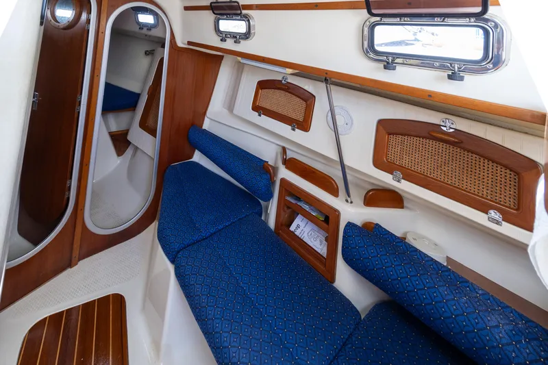 Slide: The Image of Interior of 2011 Hake Seaward 32 RK sailboat with blue seating and wooden accents. - 33
