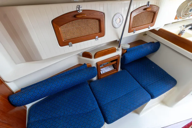 Slide: The Image of Interior seating of 2011 Hake Seaward 32 RK sailboat with blue cushions and wooden accents. - 34