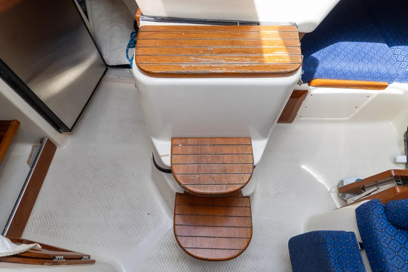 Slide: The Image of Interior of 2011 Hake Seaward 32 RK sailboat with wooden steps and blue seating. - 44