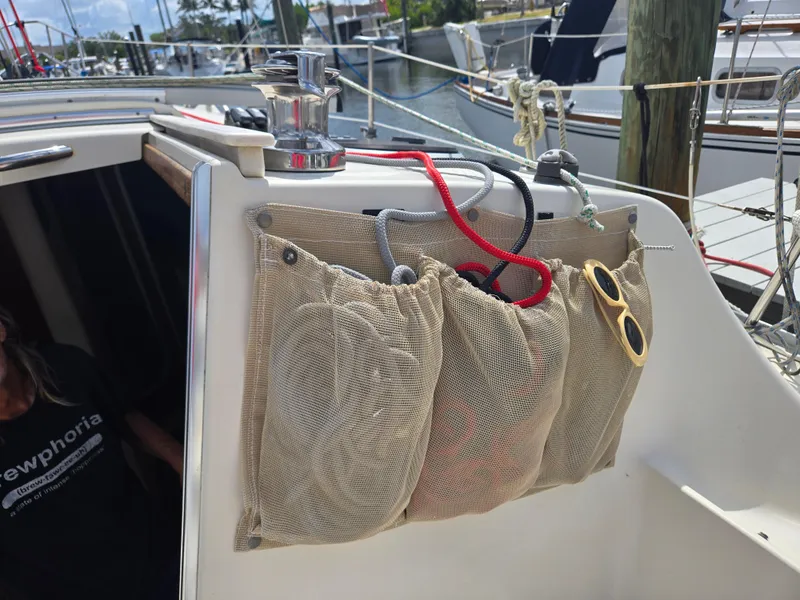 Slide: The Image of Mesh storage pockets on a 2011 Hake Seaward 32 RK sailboat, holding ropes and sunglasses. - 7