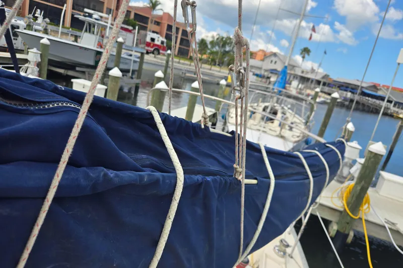 Slide: The Image of Sailboat docked at marina, featuring a 2011 Hake Seaward 32 RK with blue sail cover. - 9