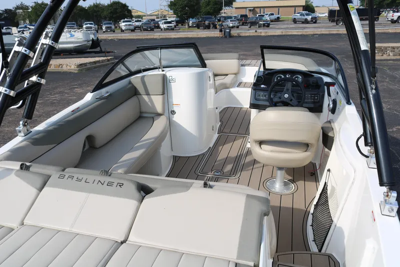 Slide: The Image of 2016 Bayliner 215 Deck Boat interior with beige seating and modern dashboard. - 17