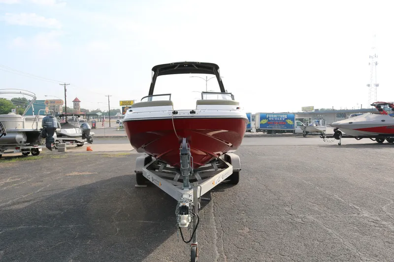 Slide: The Image of 2016 Bayliner 215 Deck Boat on trailer, parked in outdoor lot. - 2