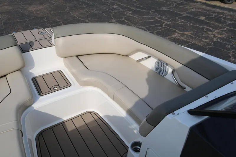 Slide: The Image of 2016 Bayliner 215 Deck Boat interior with beige seating and wood-style flooring. - 21