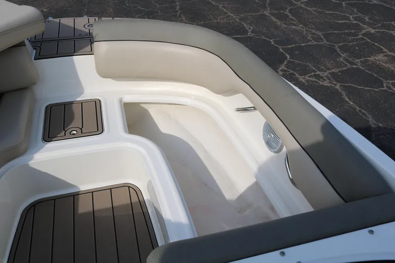 Slide: The Image of 2016 Bayliner 215 Deck Boat interior with cushioned seating and storage compartments. - 22