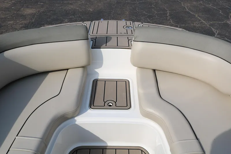 Slide: The Image of 2016 Bayliner 215 Deck Boat interior with beige seating and storage compartments. - 23